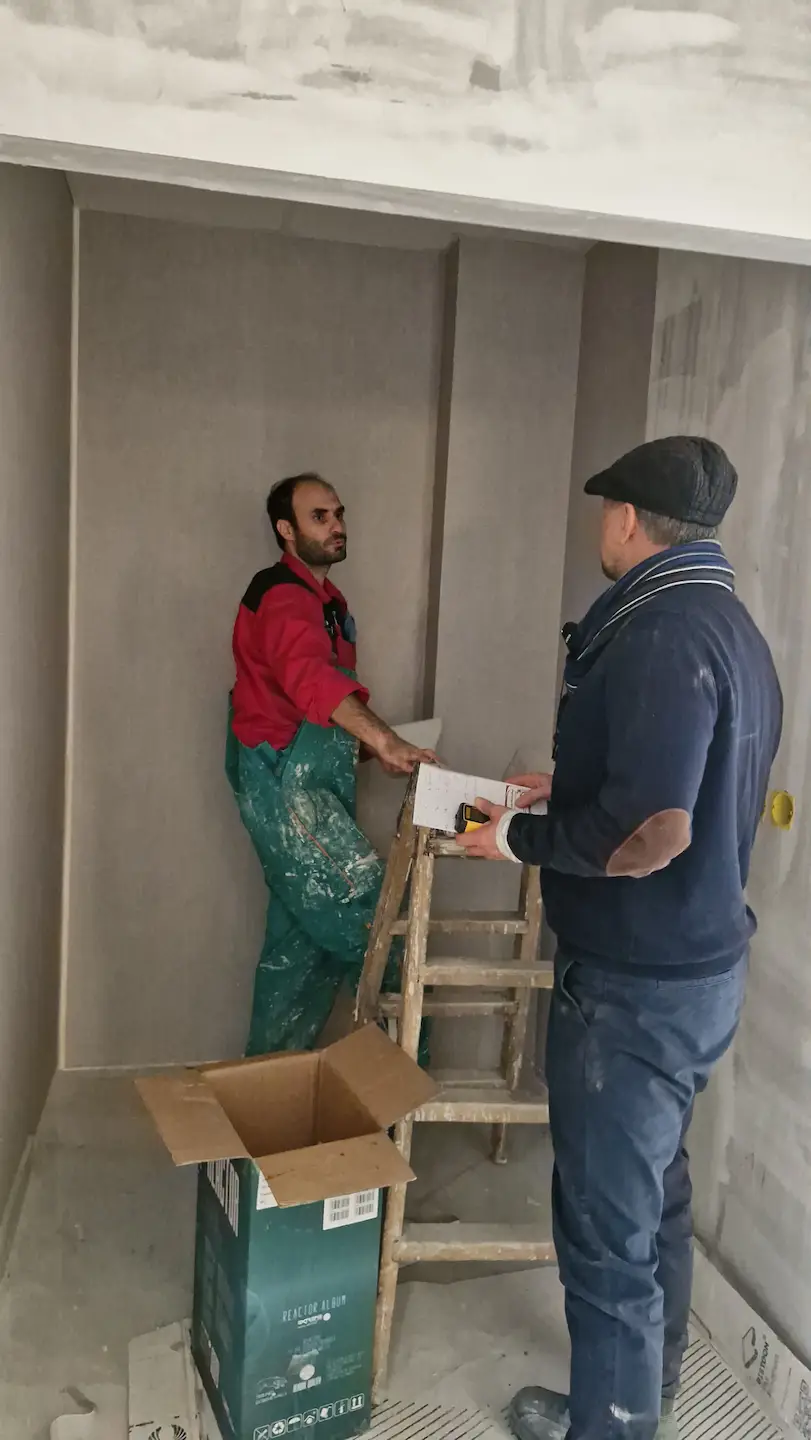 احمد مولوی درحال توضیح دادن و راهنمایی افراد برای شروع کار دیوار خشک